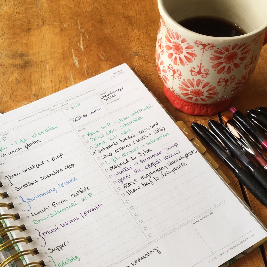 Coffee mug and daily planner with color-coded entries.